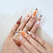 Luxury brown ombre long nails with hand-painted gold stars and floral embellishments