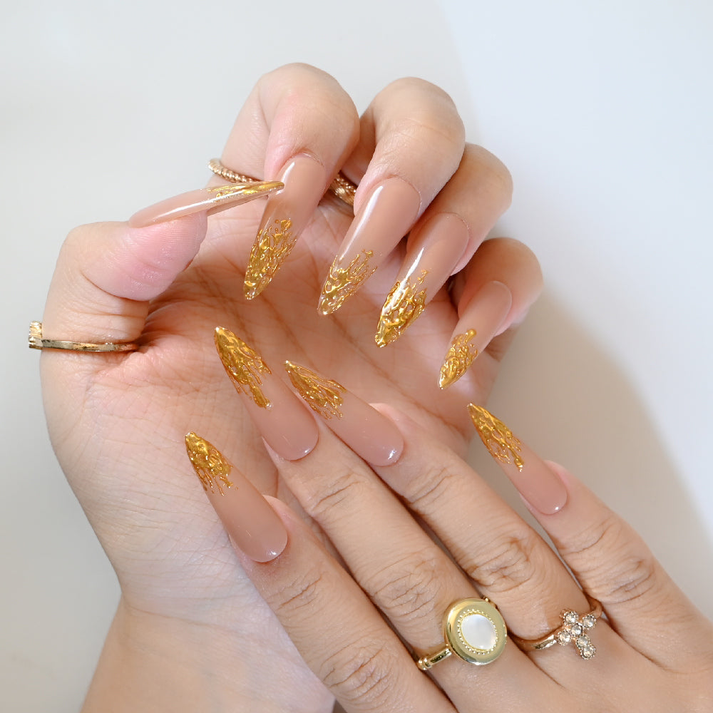 Stiletto shape nude nails with shimmering gold foil French tip effect