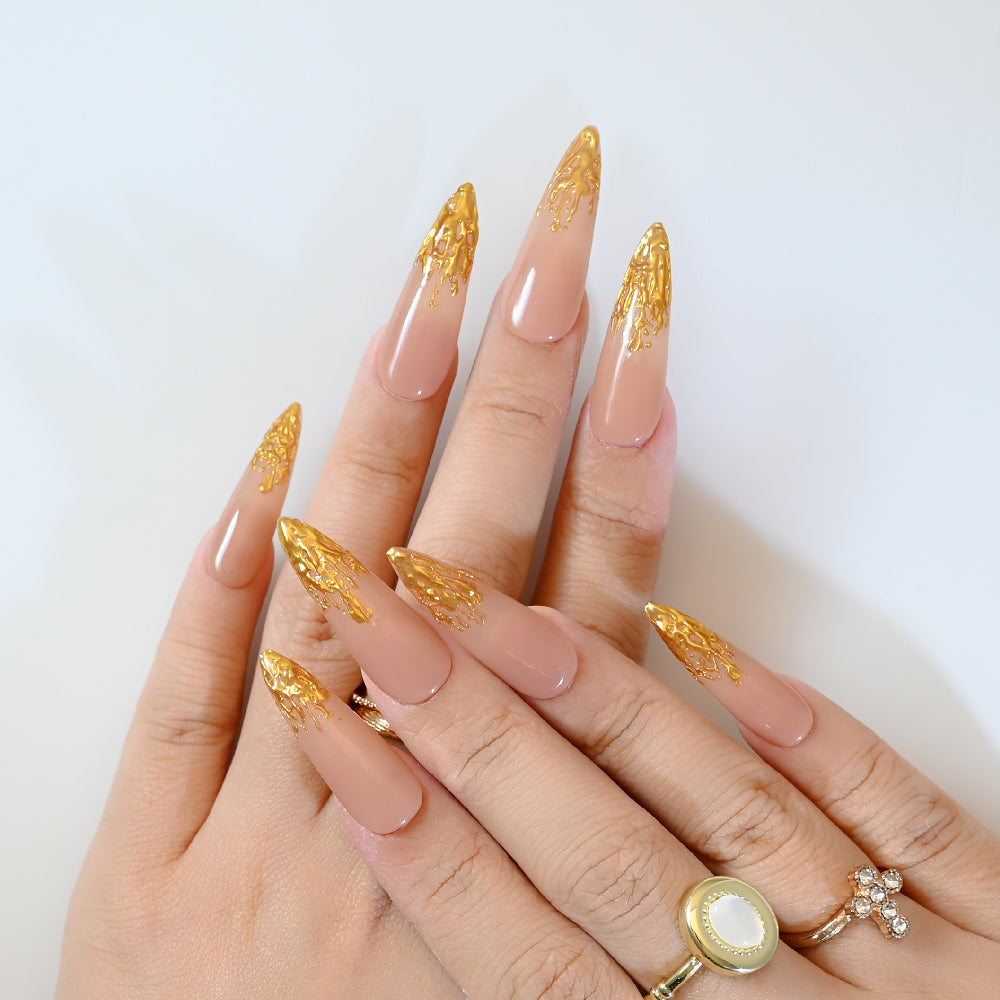 Glossy long press-on nails in caramel brown with luxury gold leaf accents