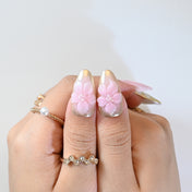 Handmade press-on nails featuring gold-edged wing pattern and 3D sakura flower