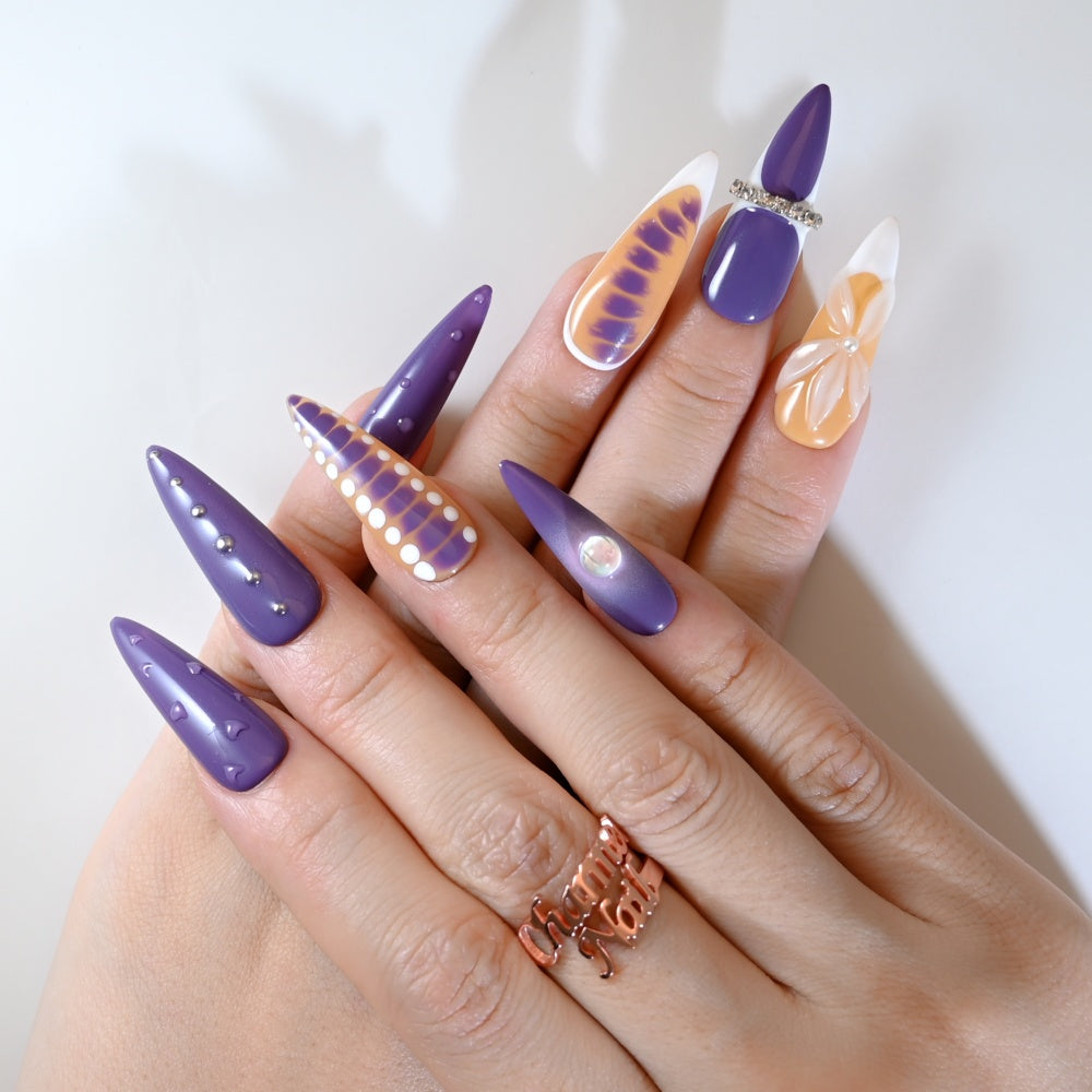 Bold purple and orange gradient press-on nails with geometric and floral designs