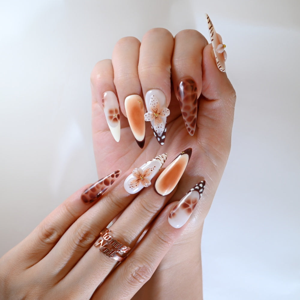 Hand-painted gradient brown nails featuring floral art and animal print patterns