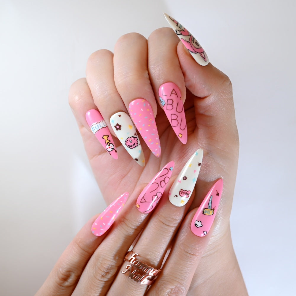 Hand-painted pink and white kawaii nails featuring LA BU BU lettering and cartoon art