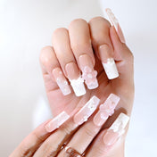 Handmade nude pink press-on nails with ribbon lacing and elegant 3D flowers