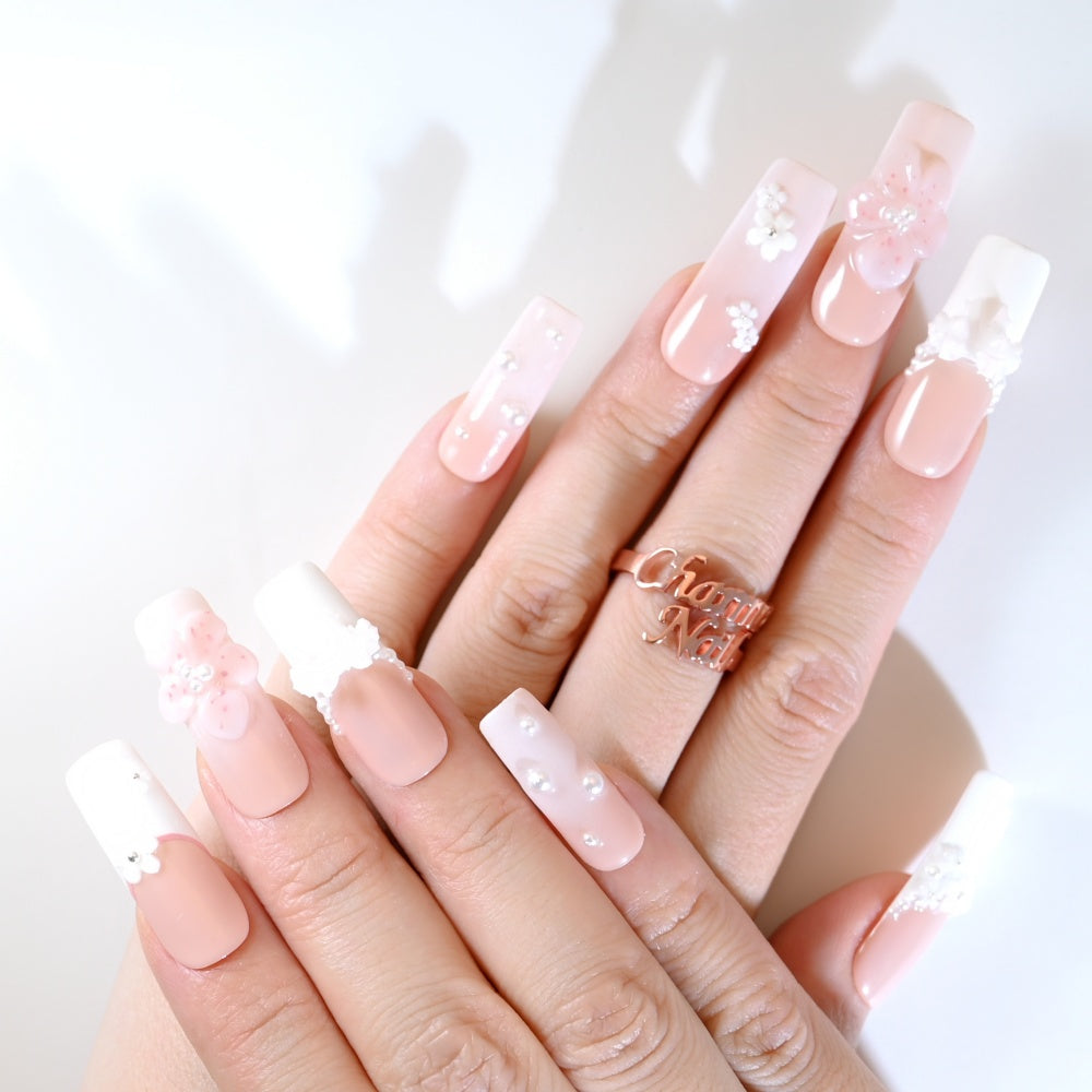 Romantic French tip press-on nails featuring delicate flowers and bead embellishments