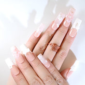 Romantic French tip press-on nails featuring delicate flowers and bead embellishments