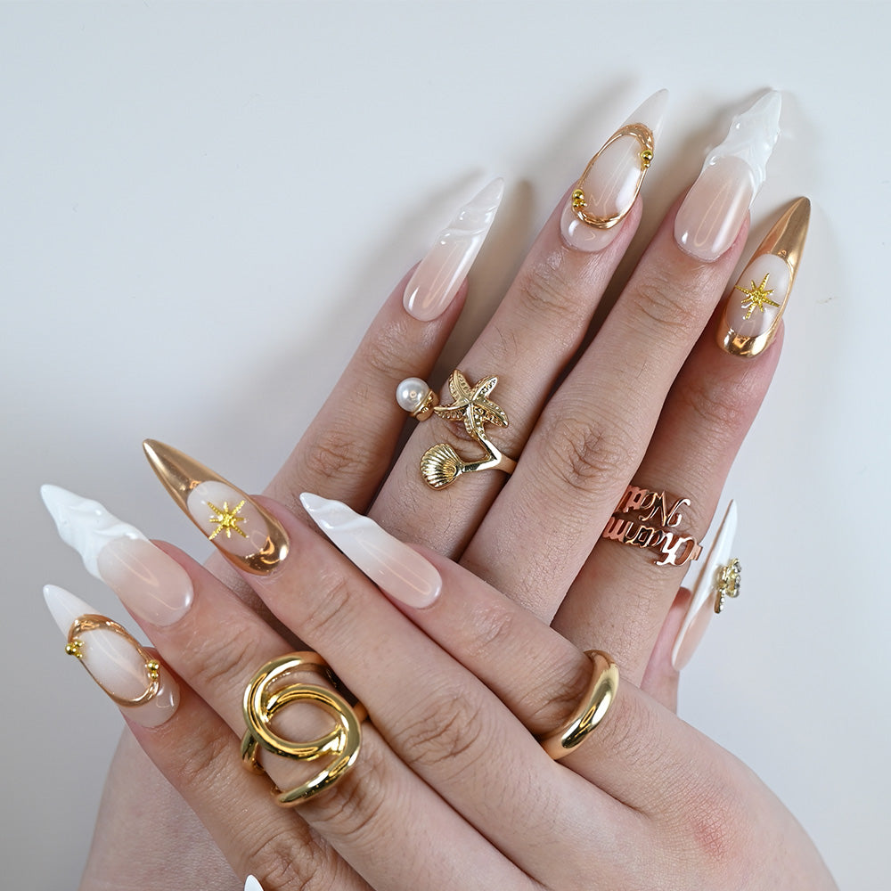 Handmade stiletto press-on nails with white sculpted tips and gold embellishments