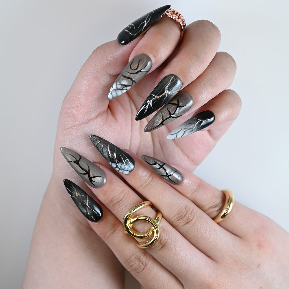 Edgy ombre stiletto nails in black, grey, and silver with abstract crackle design