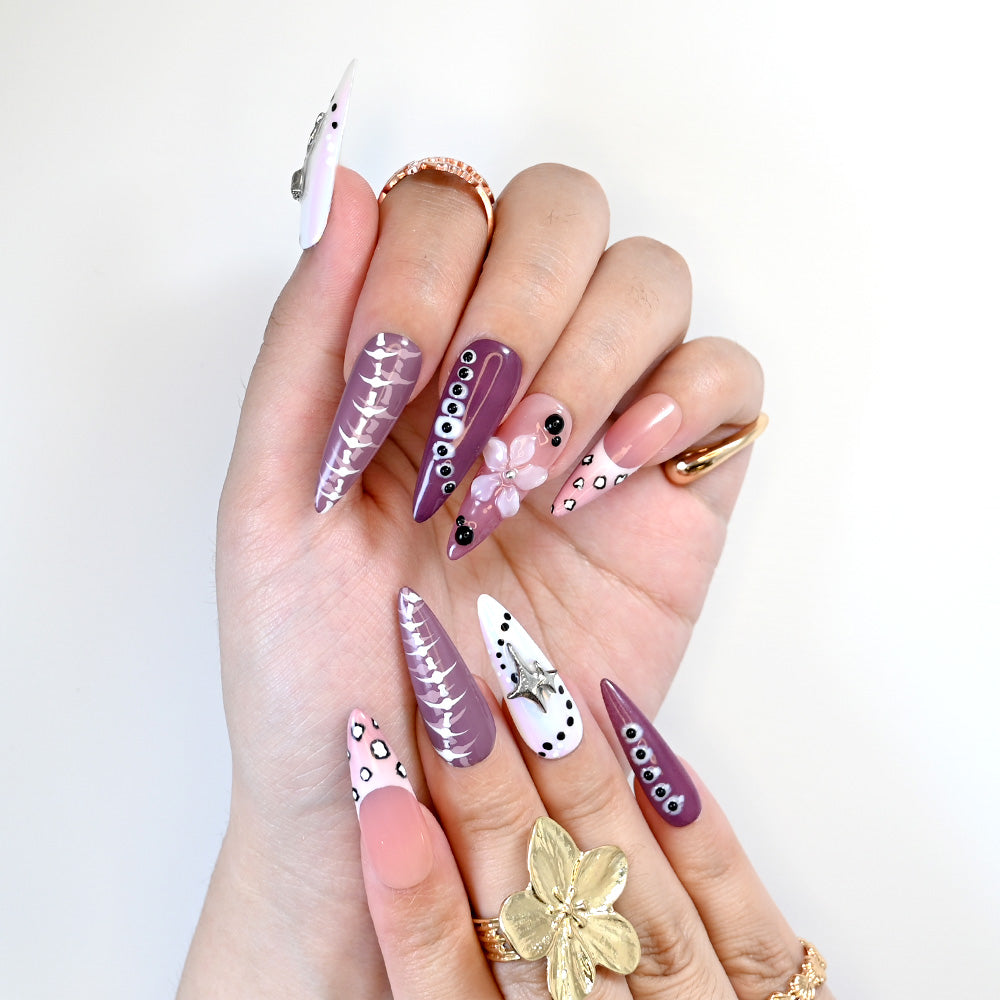 Handmade glossy nails with mauve tones, animal print accents, and metallic star charms