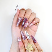 Handmade glossy nails with mauve tones, animal print accents, and metallic star charms