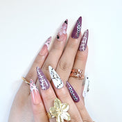 Edgy press-on nails with purple ombre, black-and-white animal patterns, and 3D embellishments