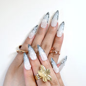 Luxury long press-on nails with gradient effect, metallic trim, and textured finish