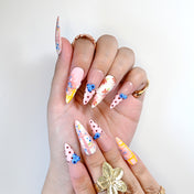 Handmade plaid nails with red polka dots, pastel yellow stripes, and floral designs