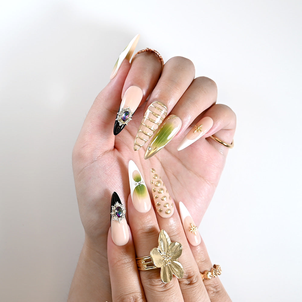 Luxury handmade nails with gradient green tips, crystal embellishments, and gold metallic details