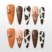 Long press-on nails with animal print, metallic bronze, and 3D floral accent