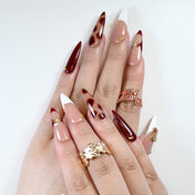 Fall party nails with cherry gem, wine red petals, and glossy finish