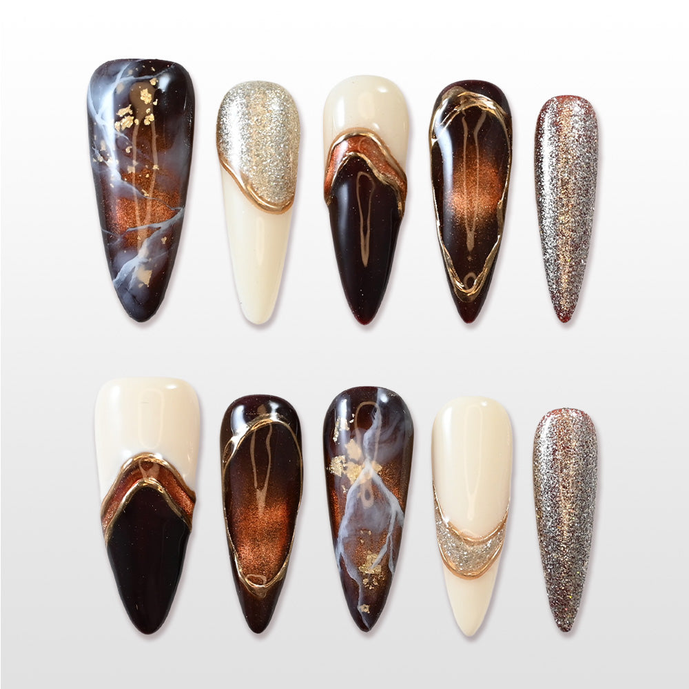 Handmade acrylic nails featuring bronze shimmer, champagne glitter, and abstract marble art