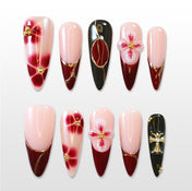 Handmade acrylic nails with wine red tips, black details, and floral nail art