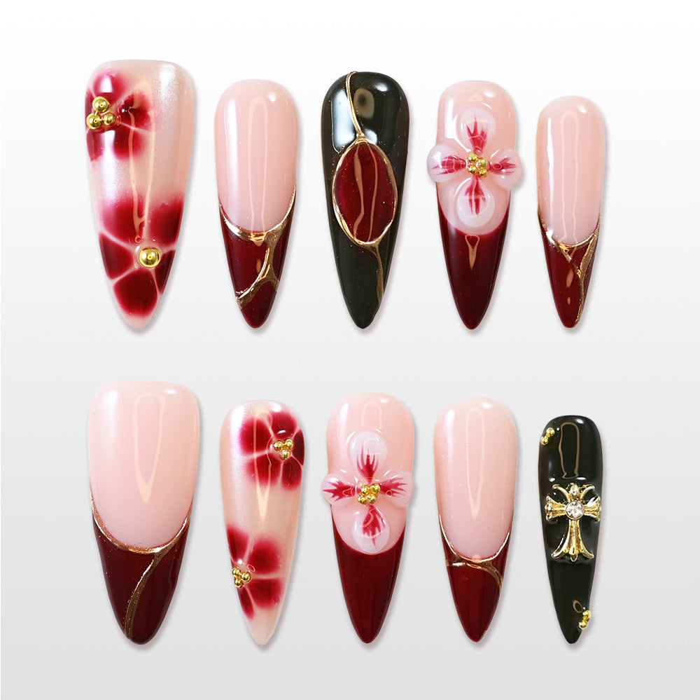 Handmade acrylic nails with wine red tips, black details, and floral nail art