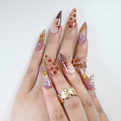 Elegant long press-on nails featuring zebra stripes, leopard spots, and gold charm"