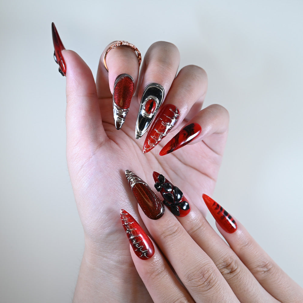 Long stiletto reusable press-on nails in red glitter with gothic accents