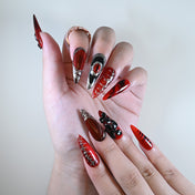 Long stiletto reusable press-on nails in red glitter with gothic accents