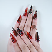 Charmeenail acrylic nails with black 3D bow, red shimmer and edgy scar effect