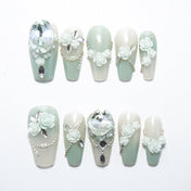 Elegant handmade nails with pearl white and mint gradient, floral art, and rhinestones
