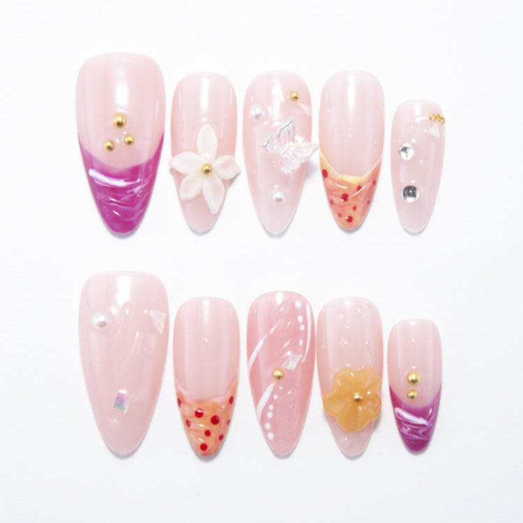 Pink press-on nails with purple tips, 3D flowers, and butterfly charm accents