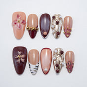 Handmade almond nails with burgundy tips, zebra accents, and pearl embellishments