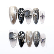 Black and gold press-on nails with silver glitter stars and 3D rose accents