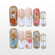 Vintage press-on nails with gold cross, angel, and rose charms