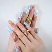 Long square reusable press-on nails with sea star charms, glitter accents, and summer vibes