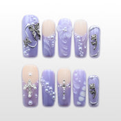 Lavender press-on nails with pearls, silver cross, and 3D floral accents
