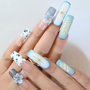 Gradient blue handmade press-on nails with gold star accents and gemstone details