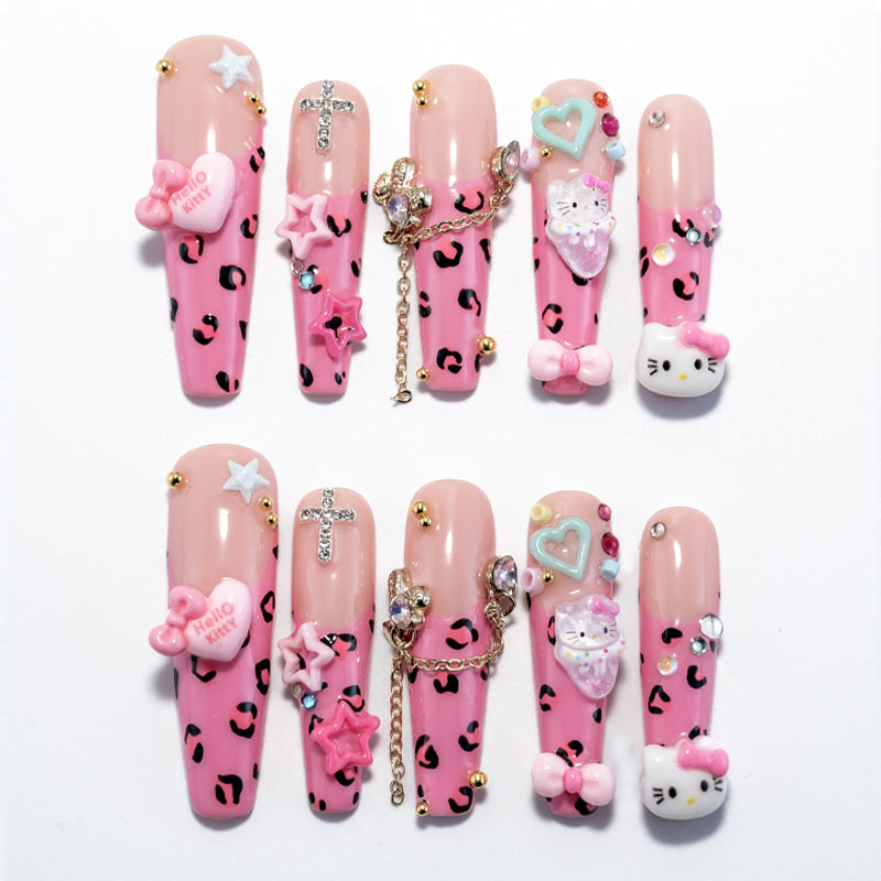 Pink leopard print press-on nails with Hello Kitty charms, 3D bows, and rhinestone chains