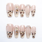 Nude and gold leopard print press-on nails with rhinestone accents