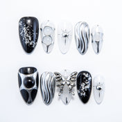 Handmade gothic nails featuring black base, silver glitter, and sculpted butterfly charm