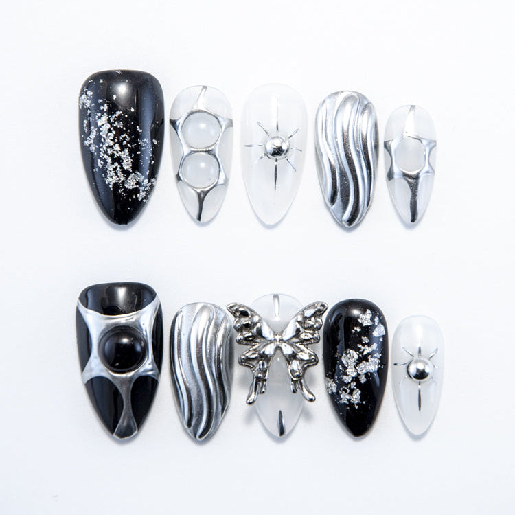 Handmade gothic nails featuring black base, silver glitter, and sculpted butterfly charm