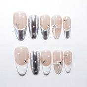 Silver and nude French tip press-on nails with white polka dots and bow design