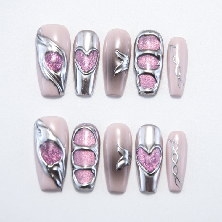 Handmade gradient nude nails with silver accents, heart designs, and shimmer pink glitter