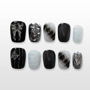 Black and silver press-on nails with metal butterfly charms and smoky gradient design