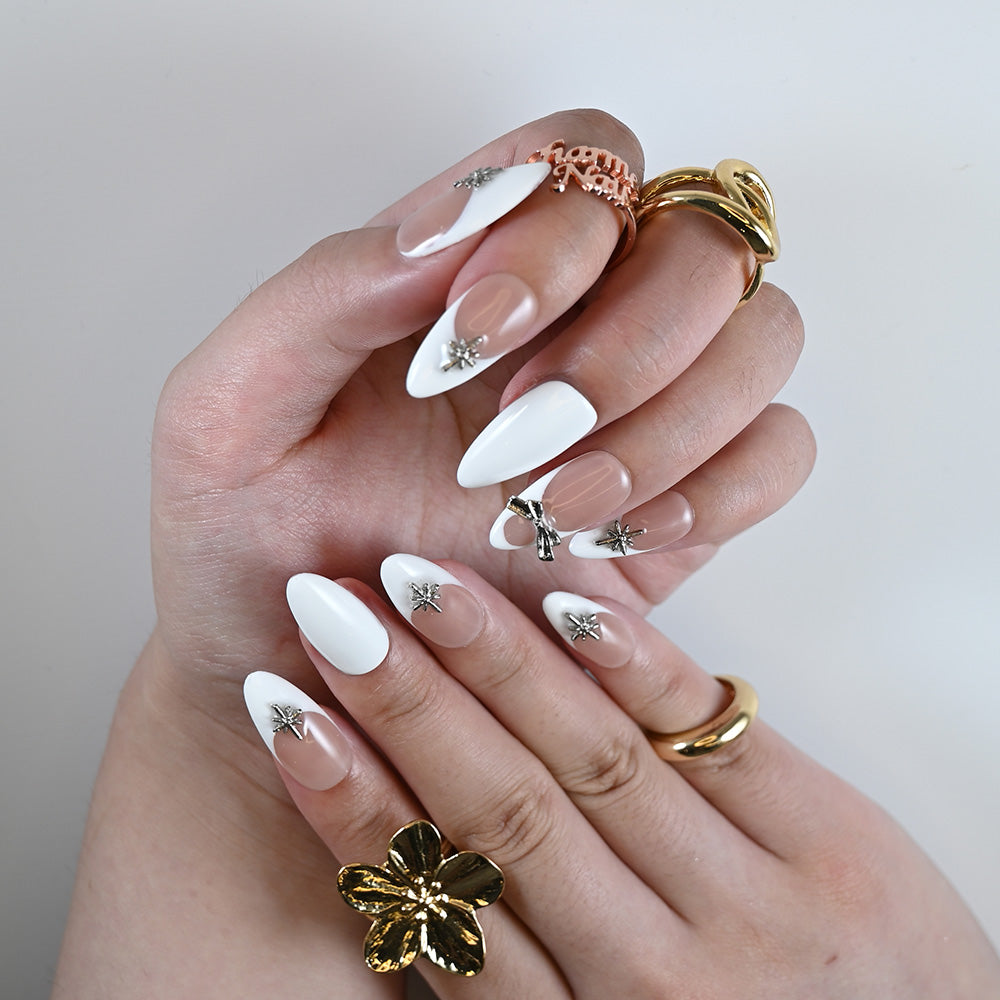 Elegant French tip press-on nails with nude base and metallic star accents