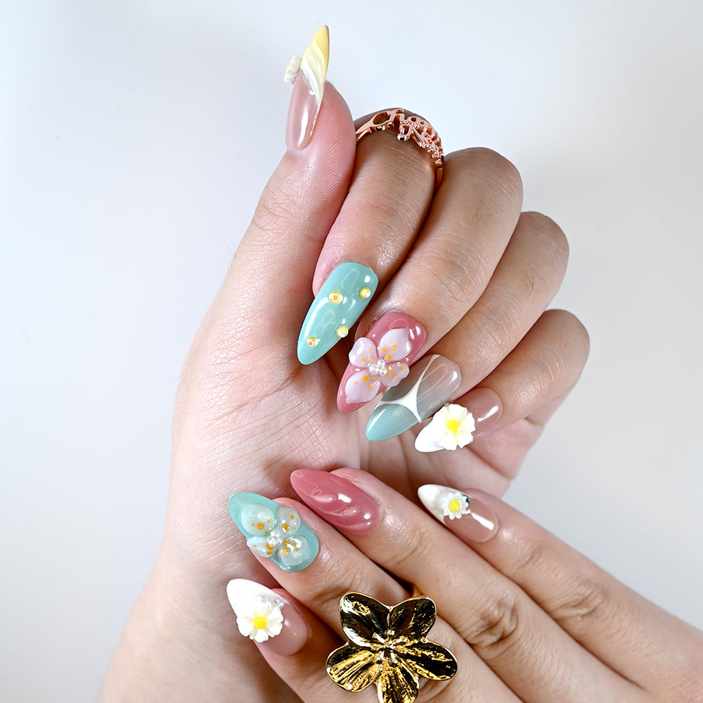 Summer press-on nails with turquoise, coral, and daisy flower embellishments
