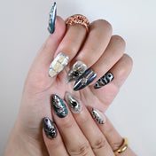Iridescent silver and black press-on nails with raised chrome texture and gems