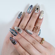Cyberpunk style press-on nails with 3D metallic texture, black pearls, and space vibes