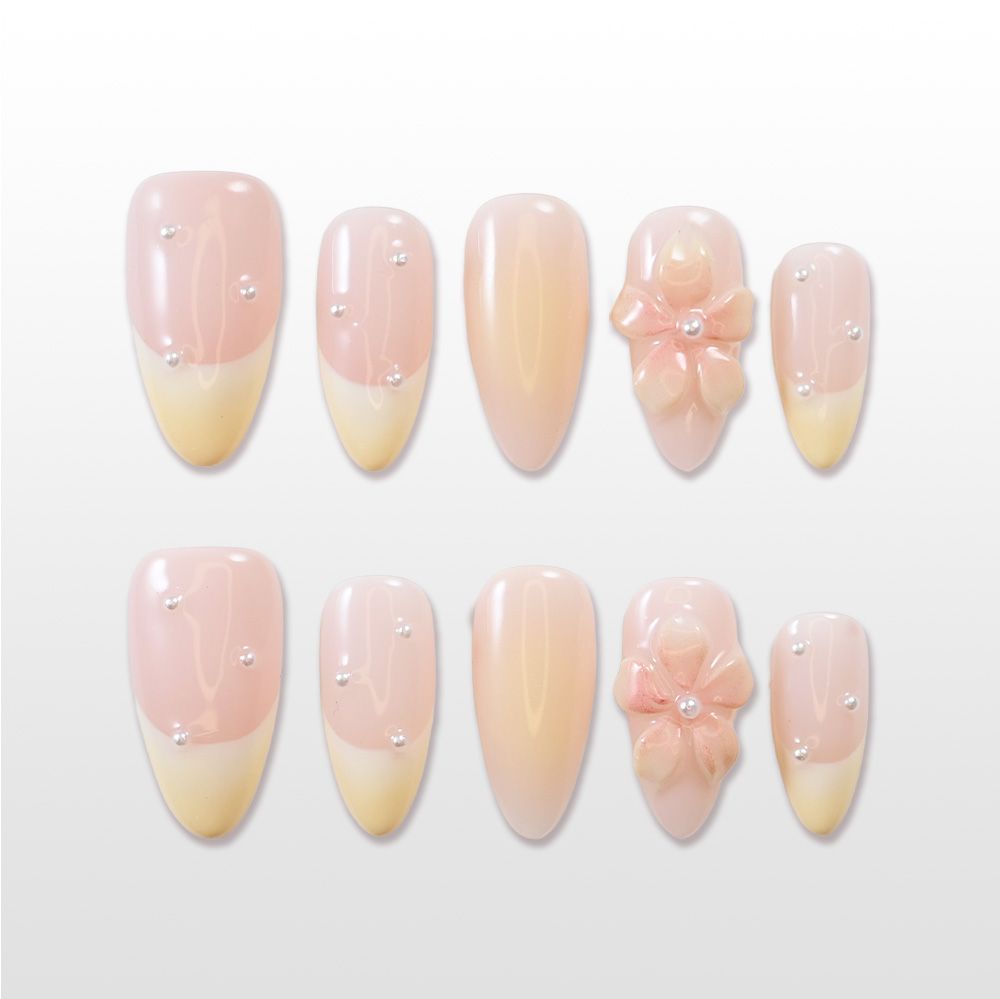 Nude French tip press-on nails with pearl accents and 3D pink flower design