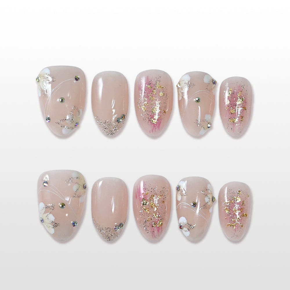 Nude pink press-on nails with gold foil and tiny white flower accents