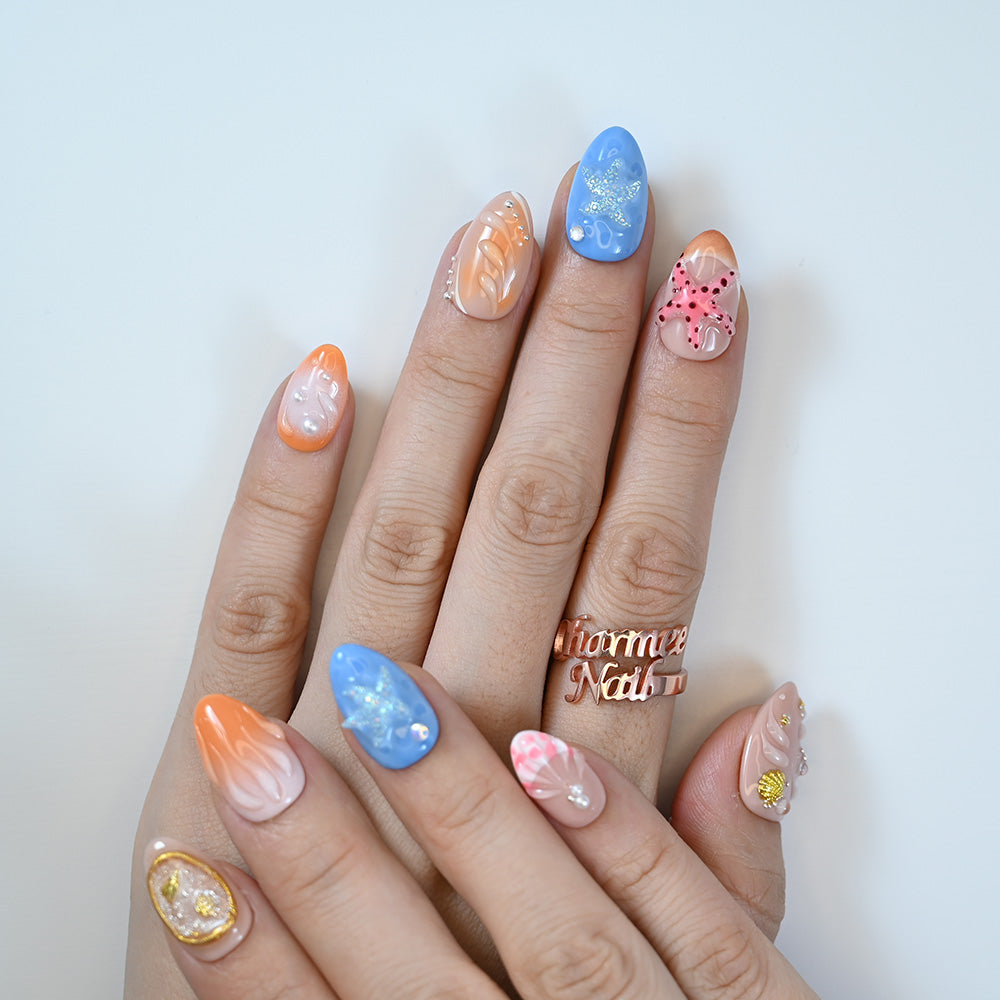 Short almond press-on nails featuring 3D starfish, shell accents, and pearls